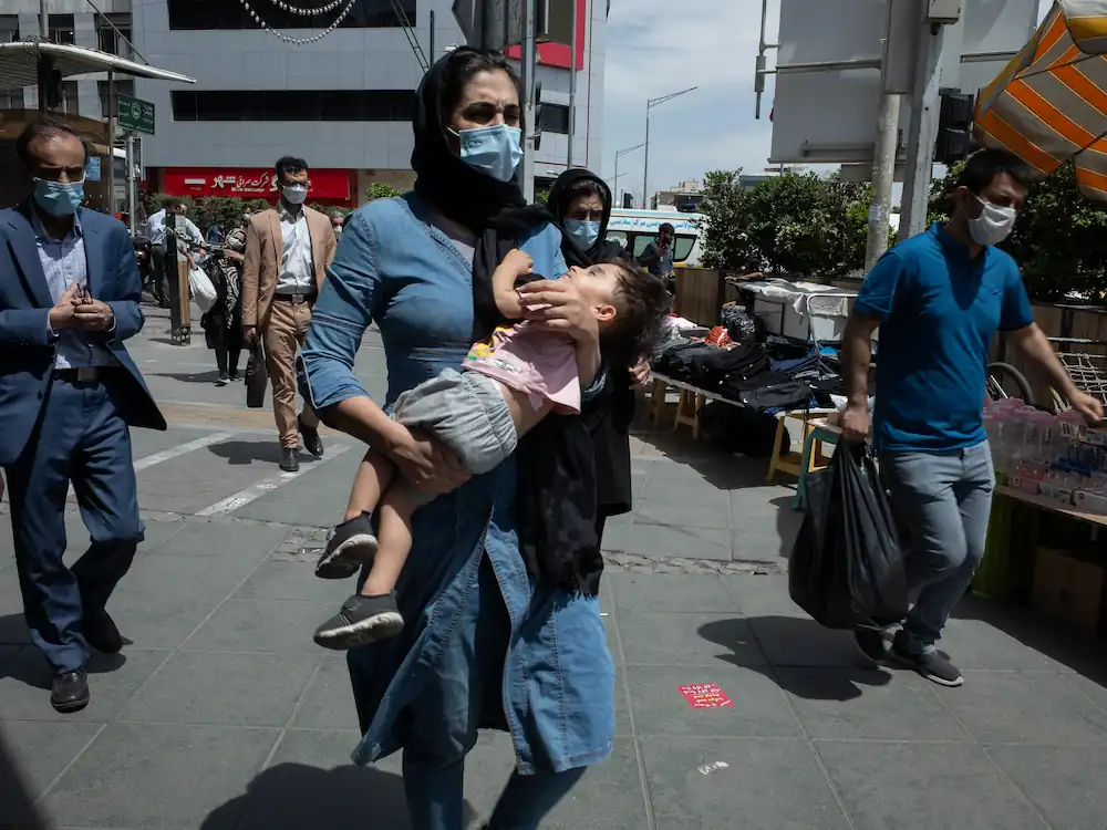 A women wearing a musk and she caring a baby 